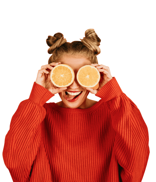 mulher segurando metades de uma laranja na posição dos olhos